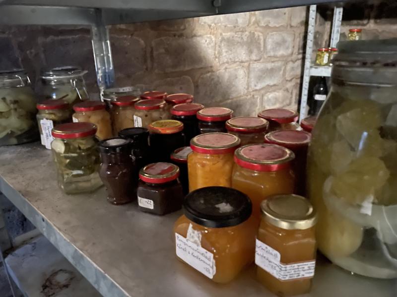 Hyllor fyllda med olika burkar med hemgjorda konserver och pickles.