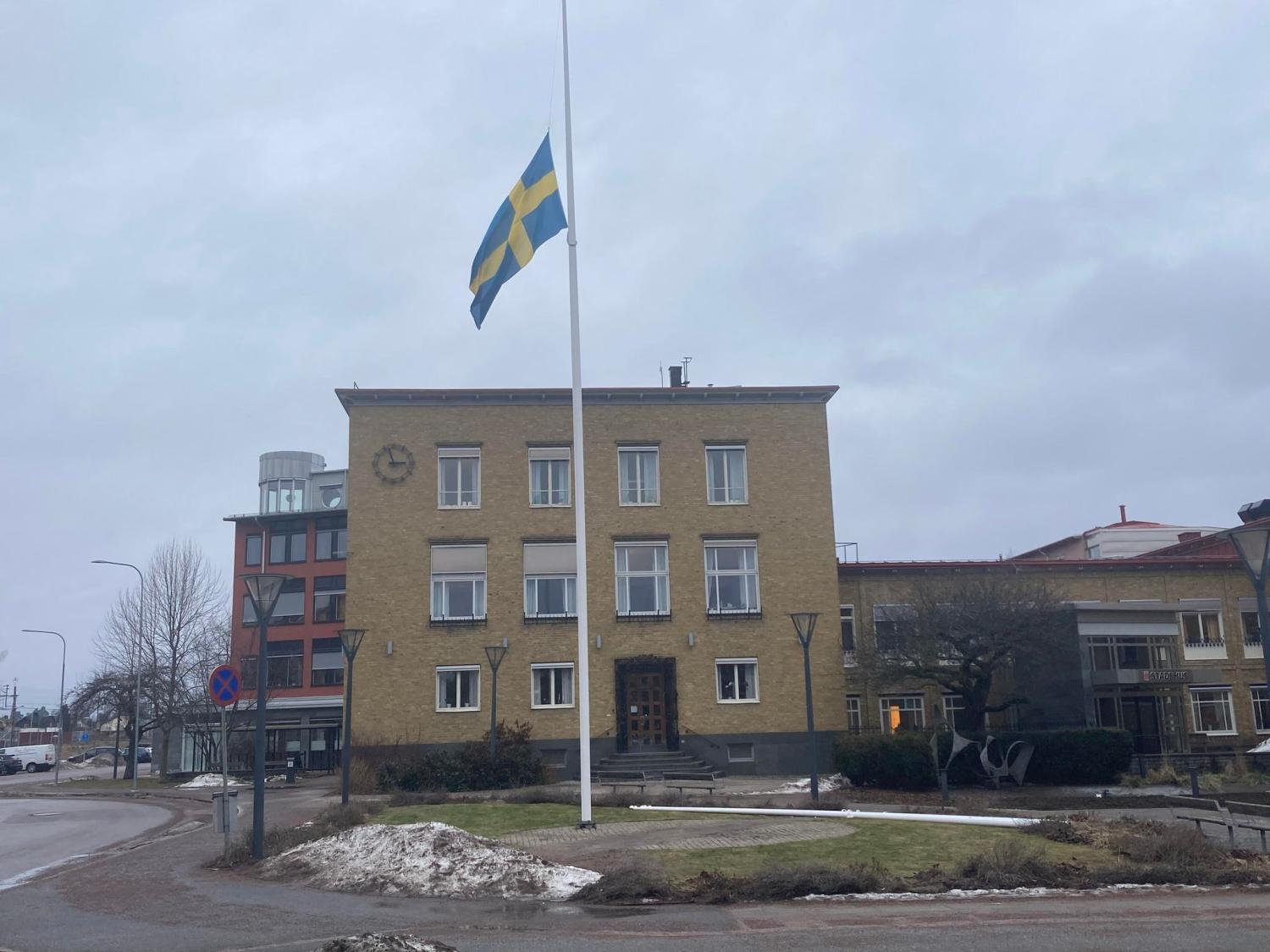 En flaggstång framför en byggnad.