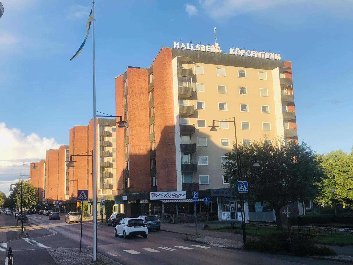 Gatuvy över en solig stadsdel med en flervåningsbyggnad märkt