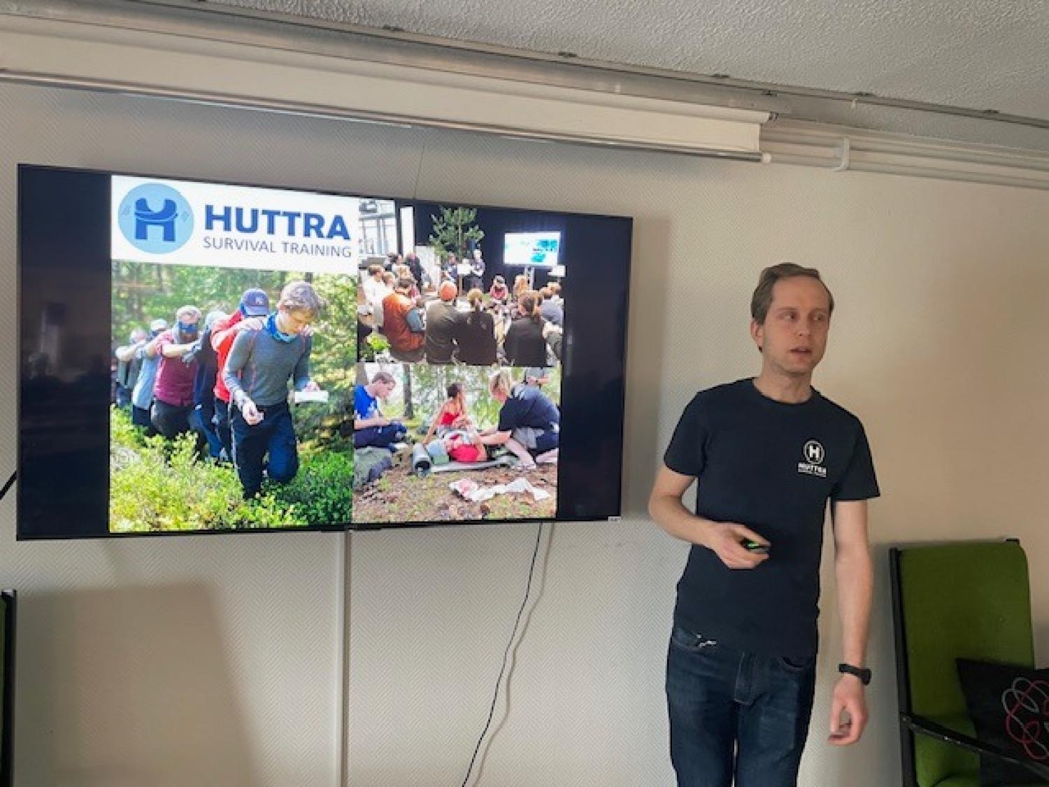 En man står bredvid en skärm som visar