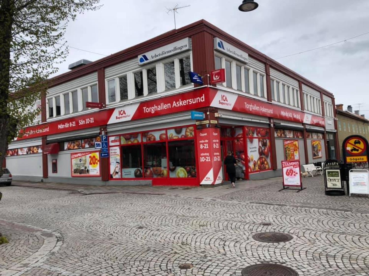 En röd och vit byggnad på en kullerstensgata.