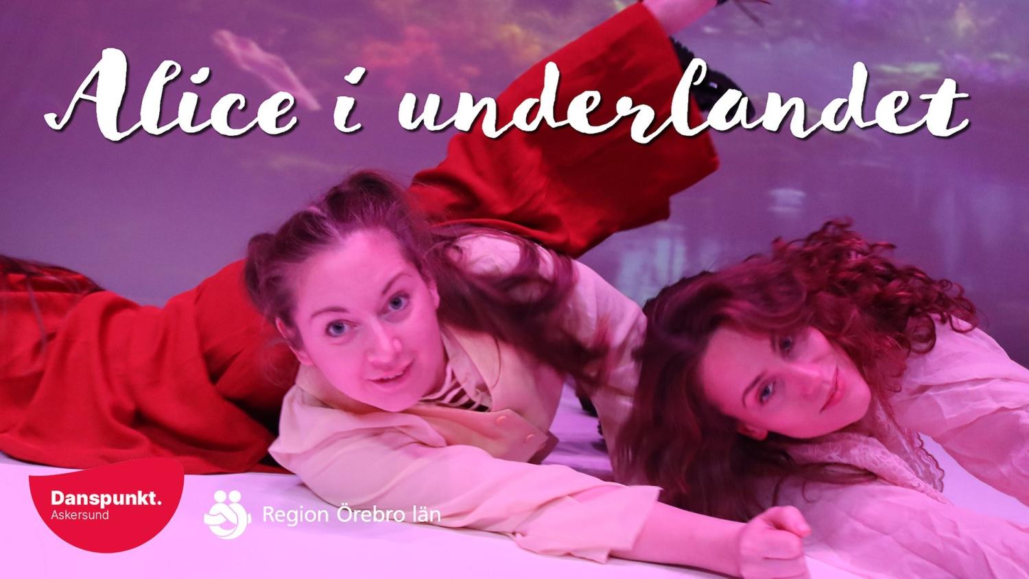 Två kostymklädda kvinnor ligger på en pastellfärgad scen under texten