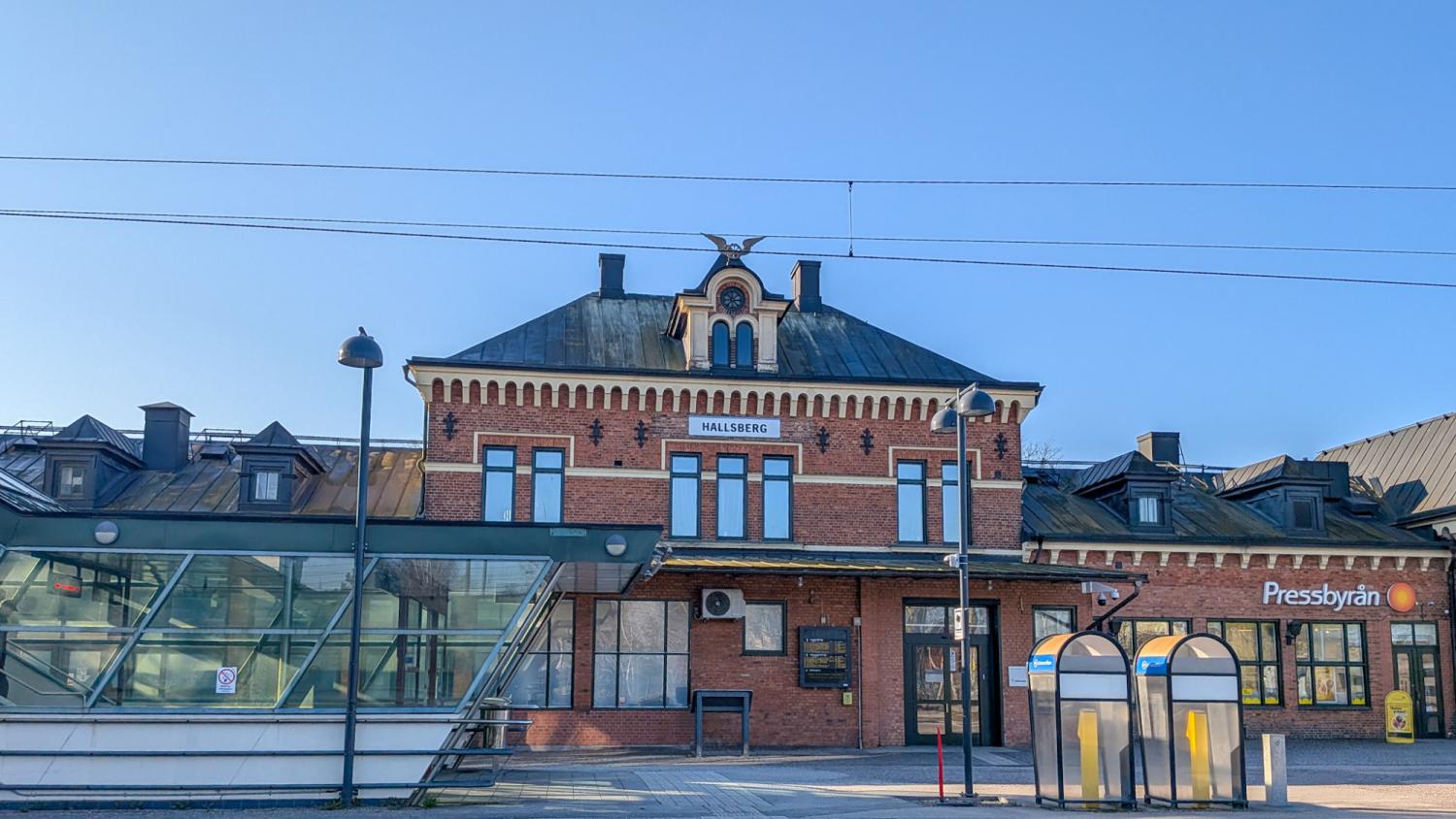 En stationsbyggnad i rött tegel med skylten
