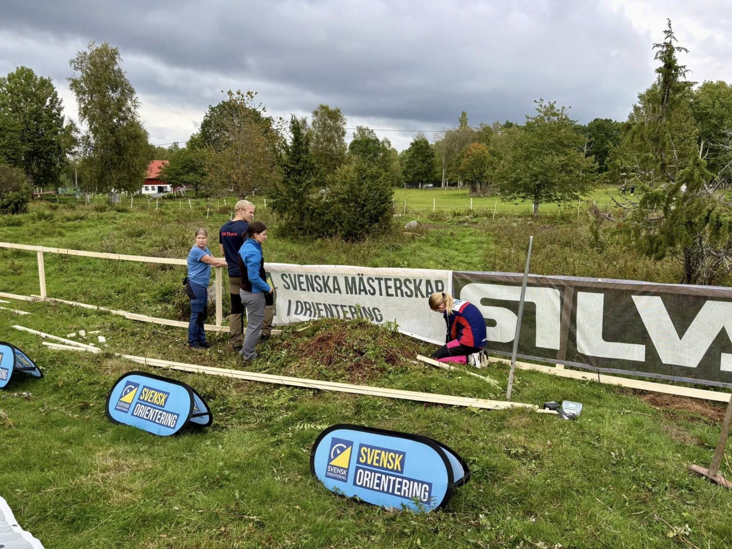 Fyra personer arbetar nära ett staket med