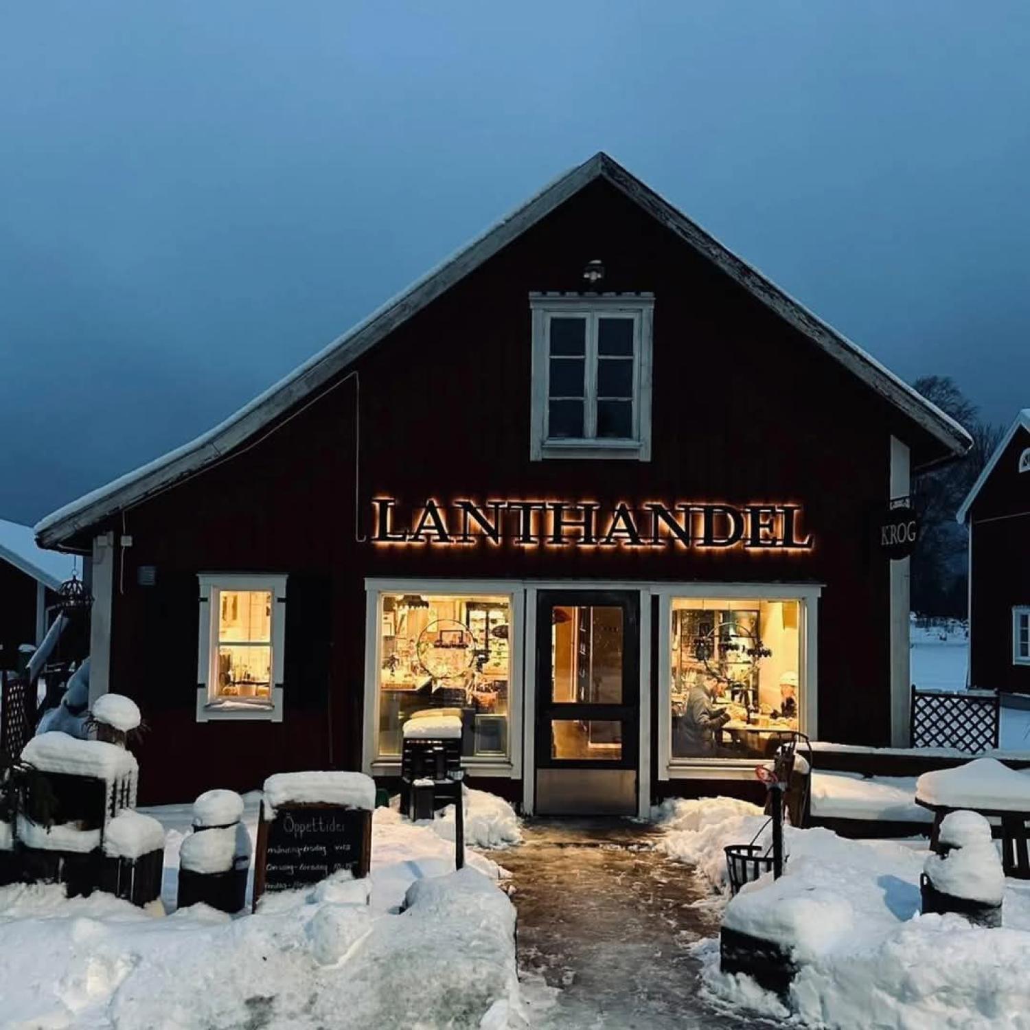 Ett varmt upplyst skyltfönster i en träbyggnad märkt