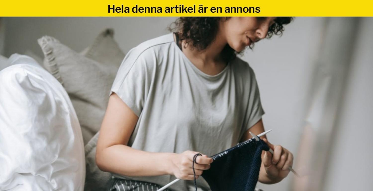En person sitter inomhus och stickar.