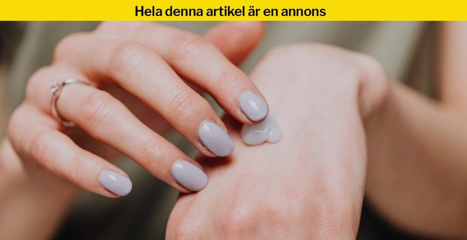 En person med ljuslila nagellack smörjer in baksidan av handen med kräm.