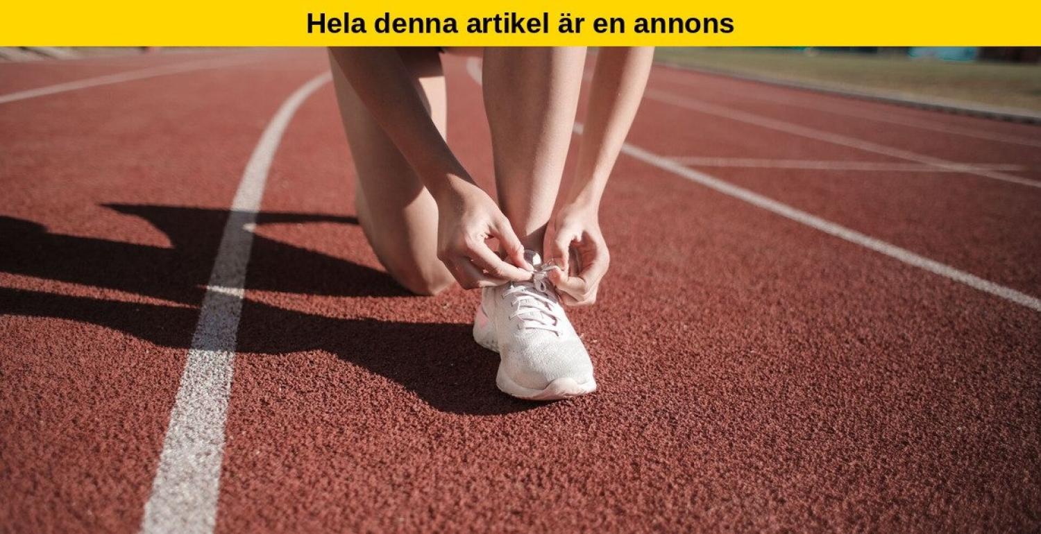 En person som knäböjer på en löparbana och knyter skosnörena på sina vita sneakers.