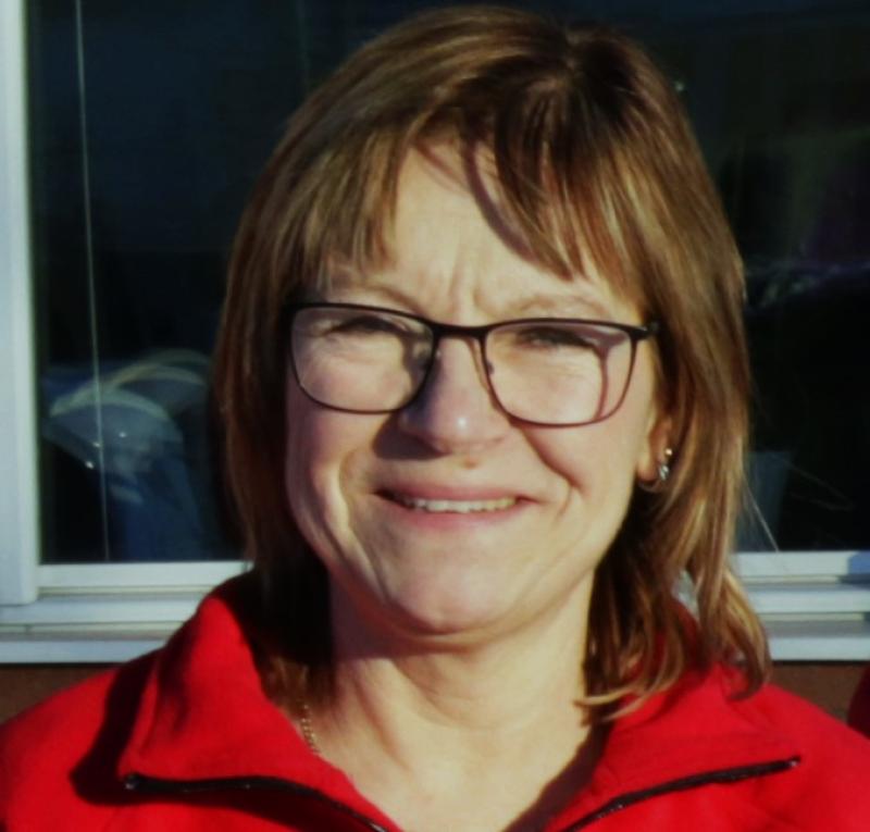 En kvinna som bär glasögon och en röd jacka.