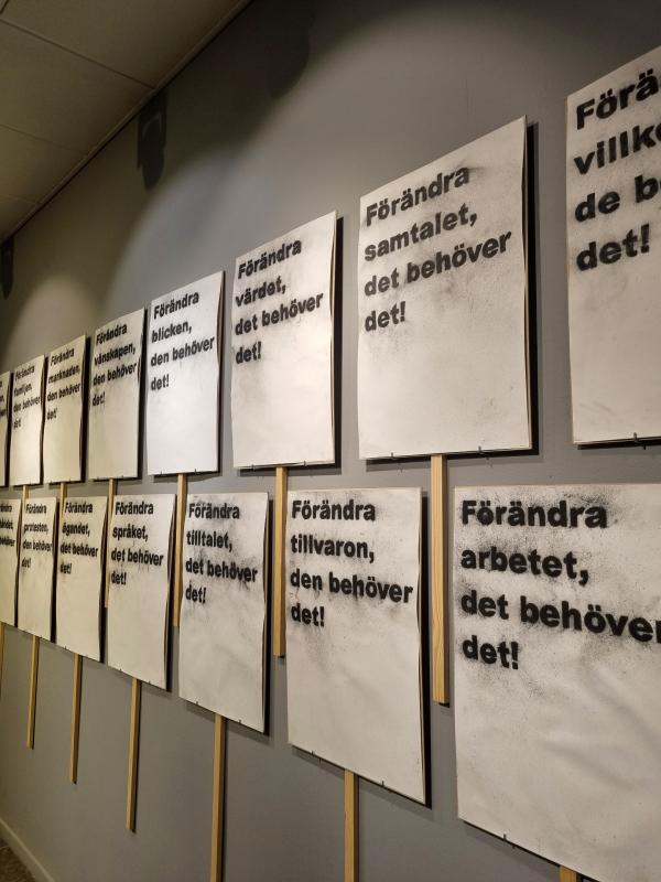 En rad vita affischer med svart svensk text, som alla börjar med 