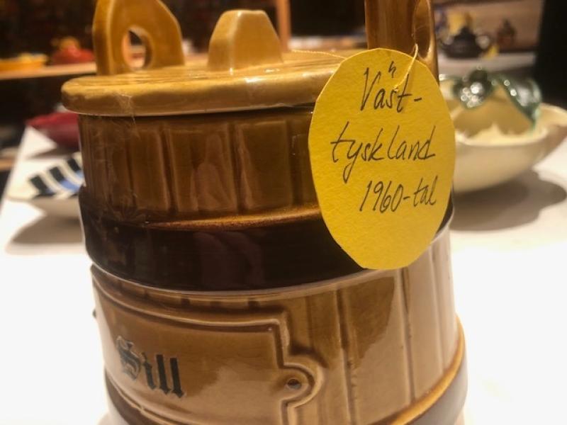 En brun keramikbehållare med en gul etikett med texten 