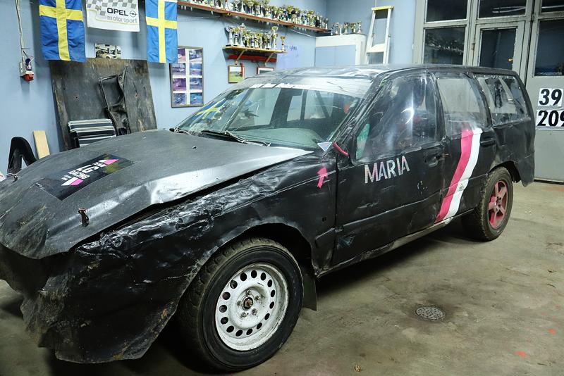 En kraftigt skadad svart kombi märkt 