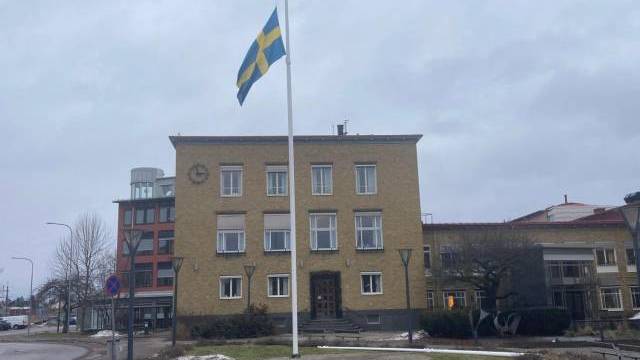 En flaggstång framför en byggnad.