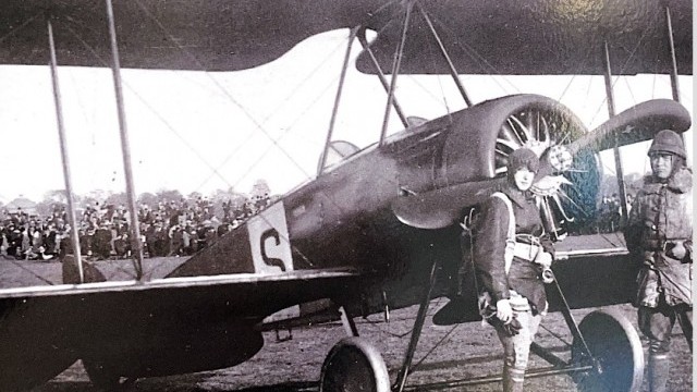 En ung kvinna står framför ett flygplan