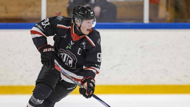 Ishockeyspelare i svart uniform och hjälm, med nummer 97 och lagkaptenens 