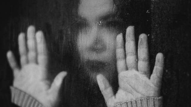 Ett svartvitt foto av en kvinna med händerna ut.