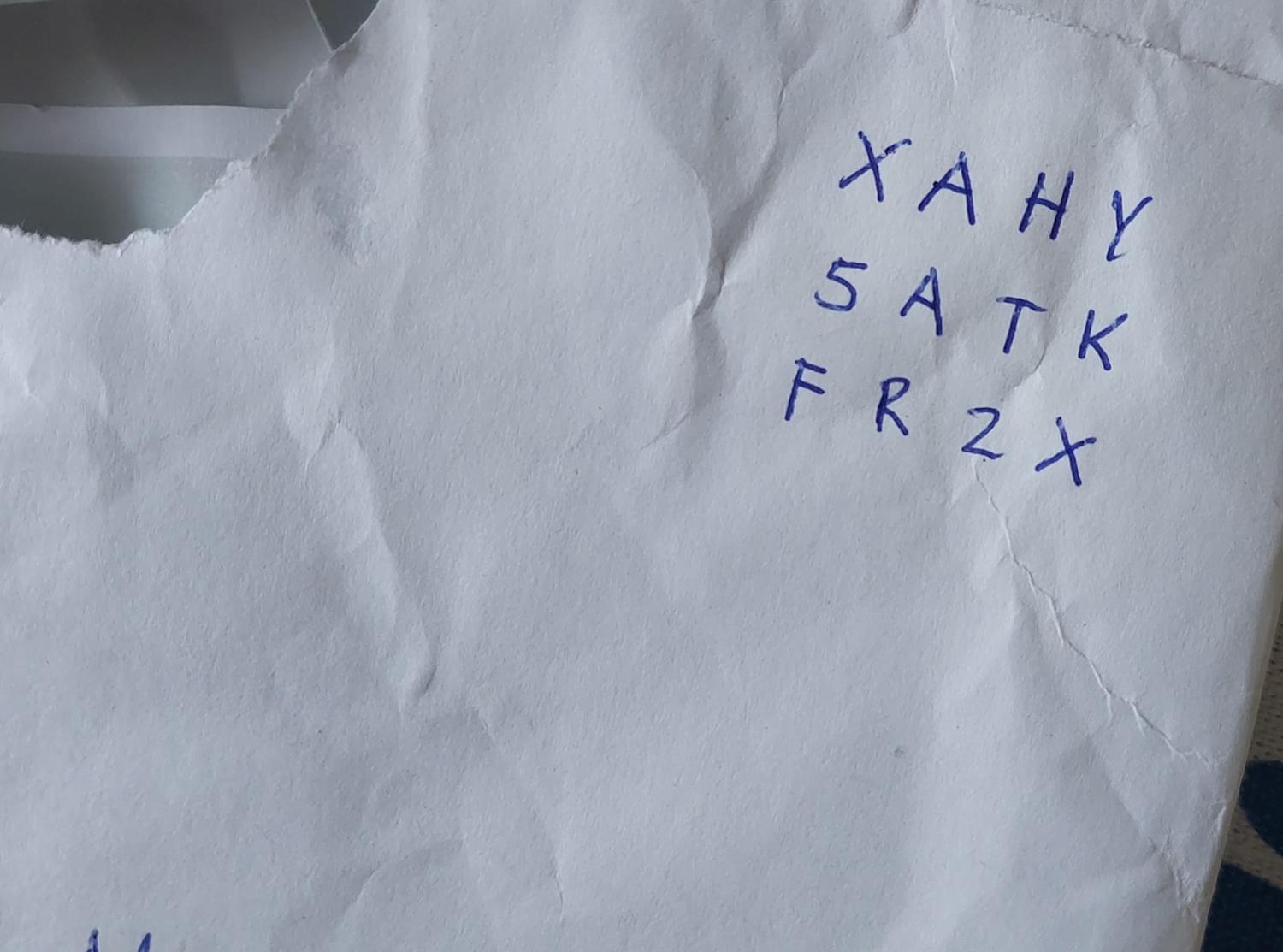 Ett skrynkligt papper med de handskrivna bokstäverna och siffrorna 