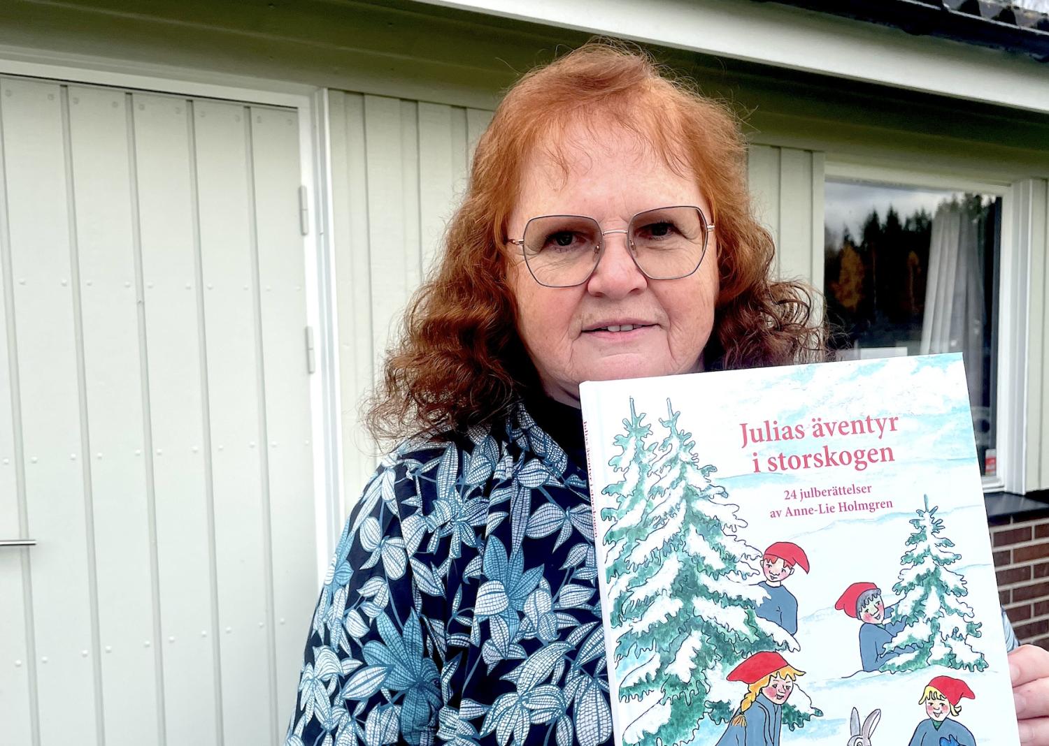 En kvinna som håller upp en bok med en bild av en jultomte.