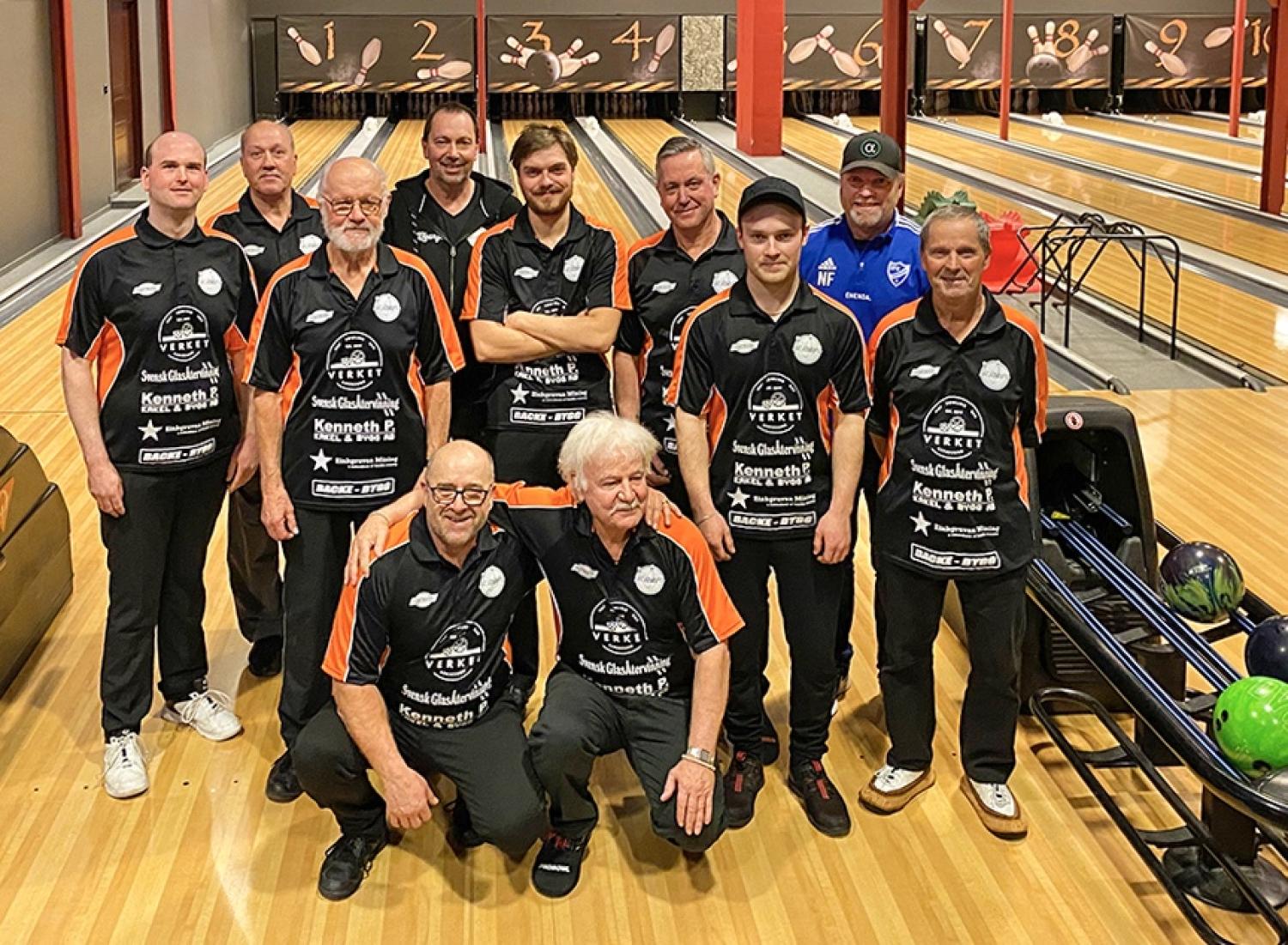En grupp män poserar för ett foto i en bowlinghall.