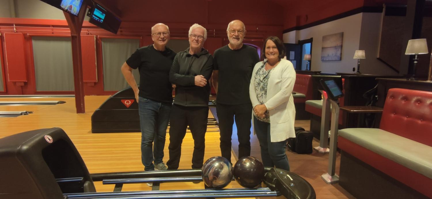 En grupp människor poserar för en bild i en bowlinghall.