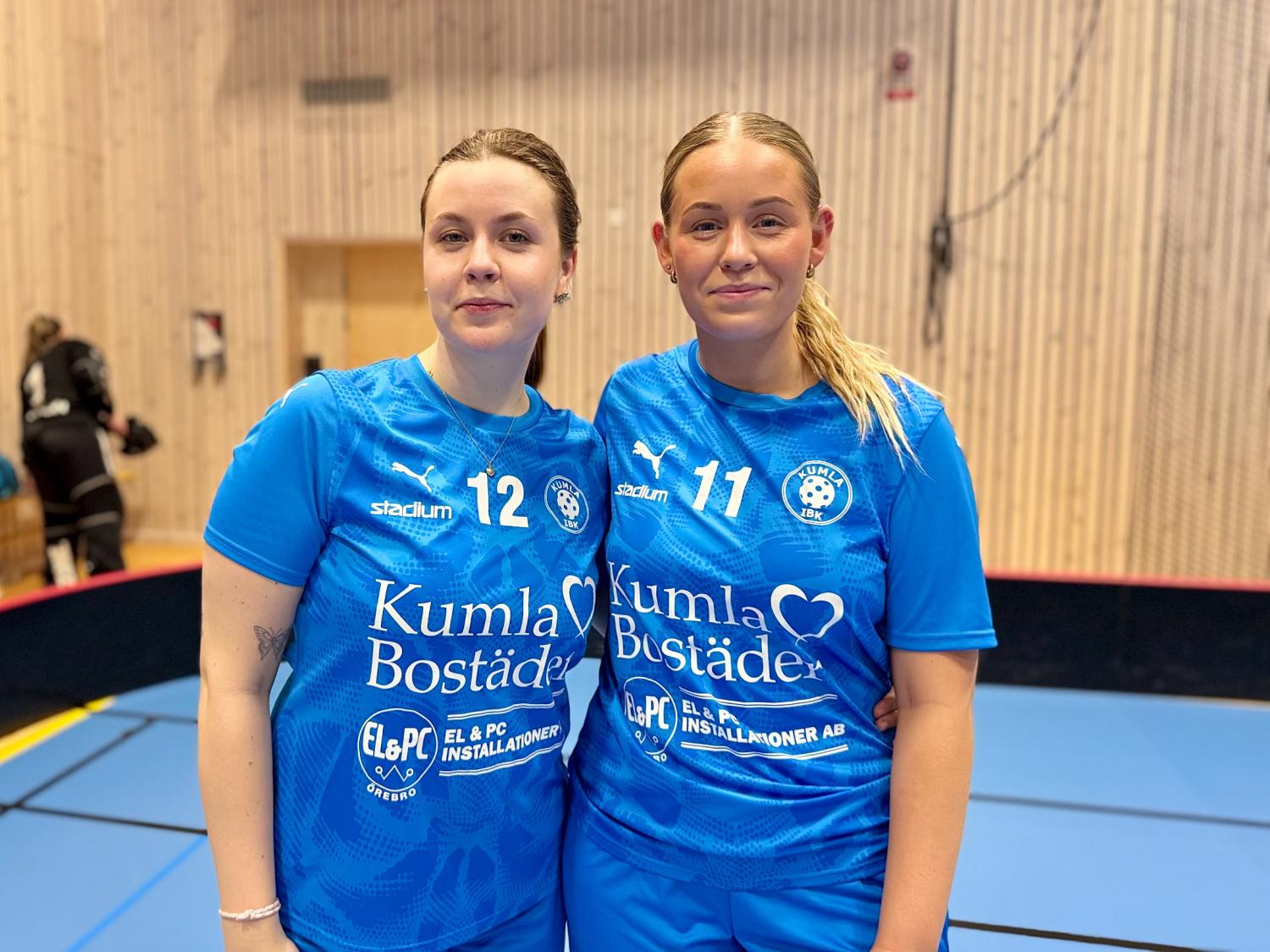 Två kvinnor i blå sportuniformer med 