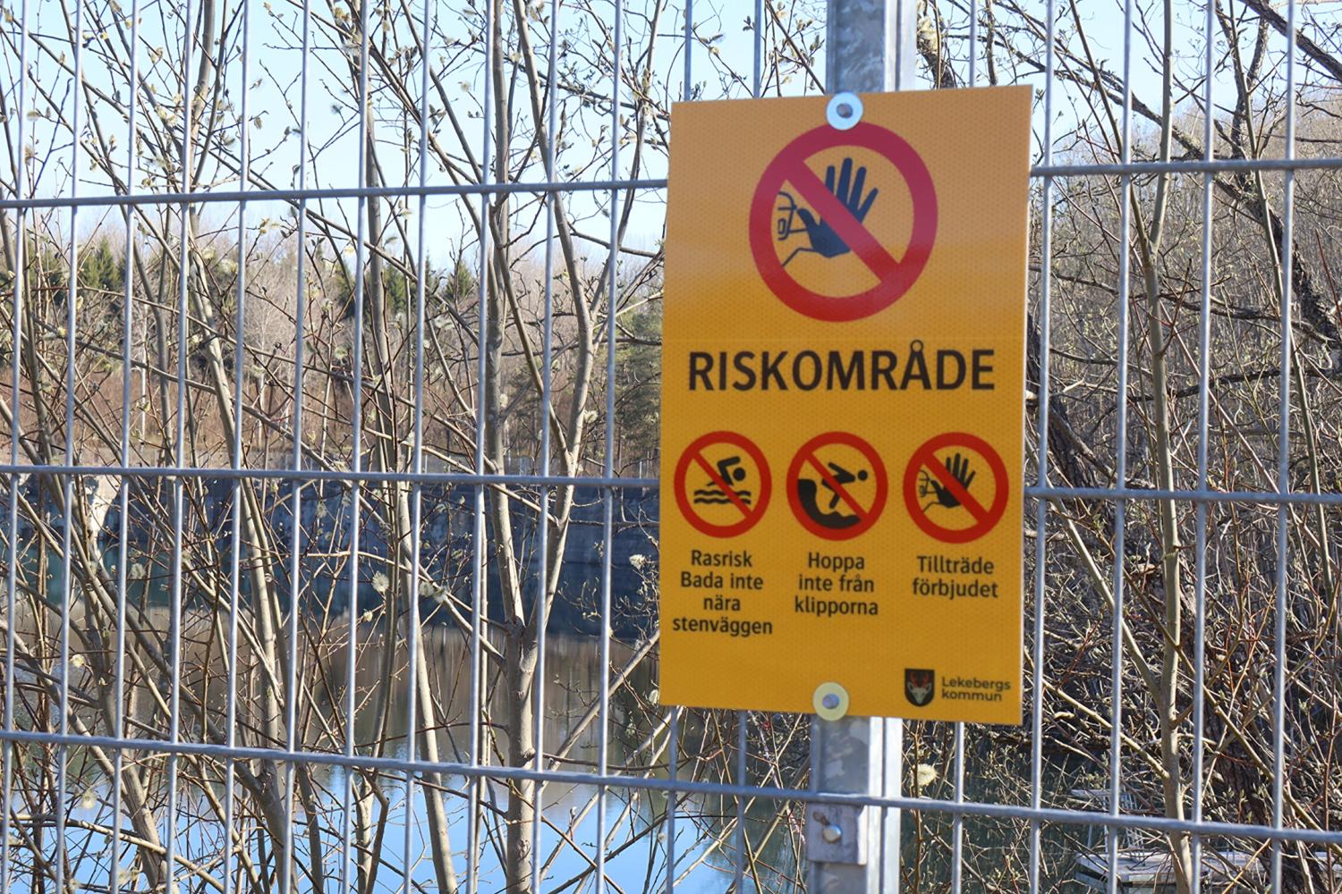 På en varningsskylt på ett staket står det 