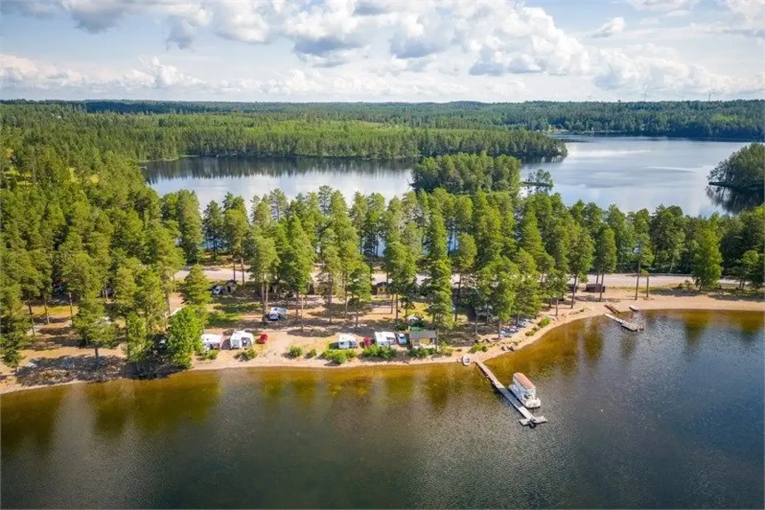 Flygfoto över en sjö och campingplatser.