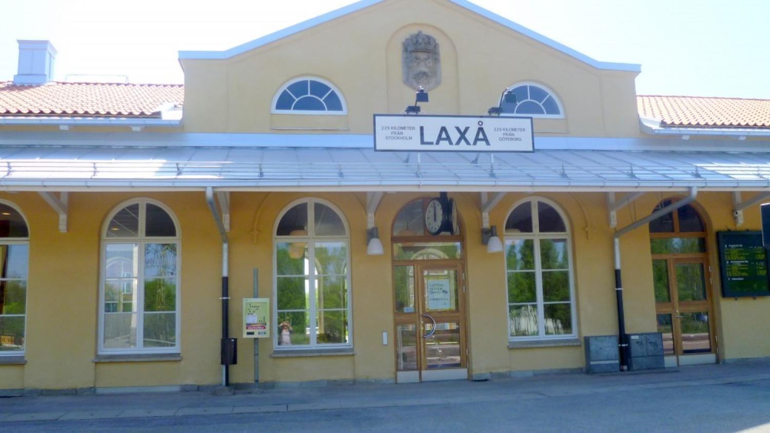 Gul byggnad med välvda fönster och en skylt med texten 