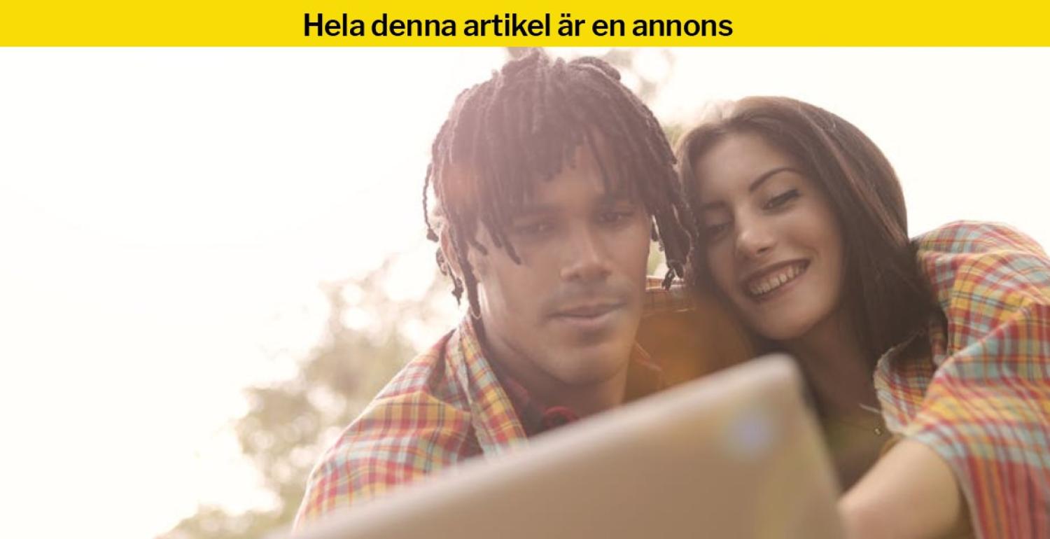 En man och en kvinna sitter tätt intill varandra, ler och tittar på en laptopskärm utomhus.
