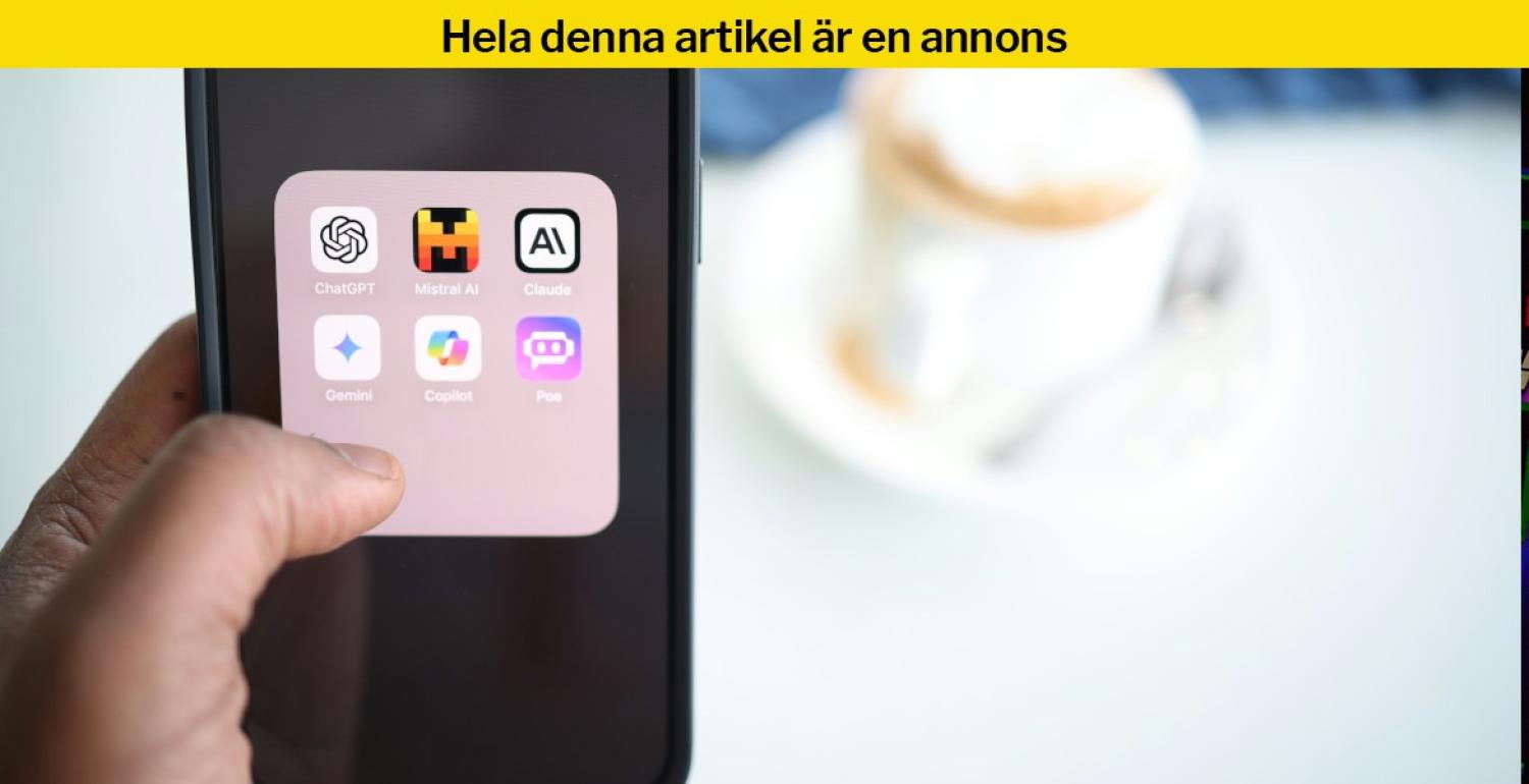 En hand som håller en smartphone visar en mapp med ikoner för AI-appar. I bakgrunden står en suddig kaffekopp på ett vitt bord.