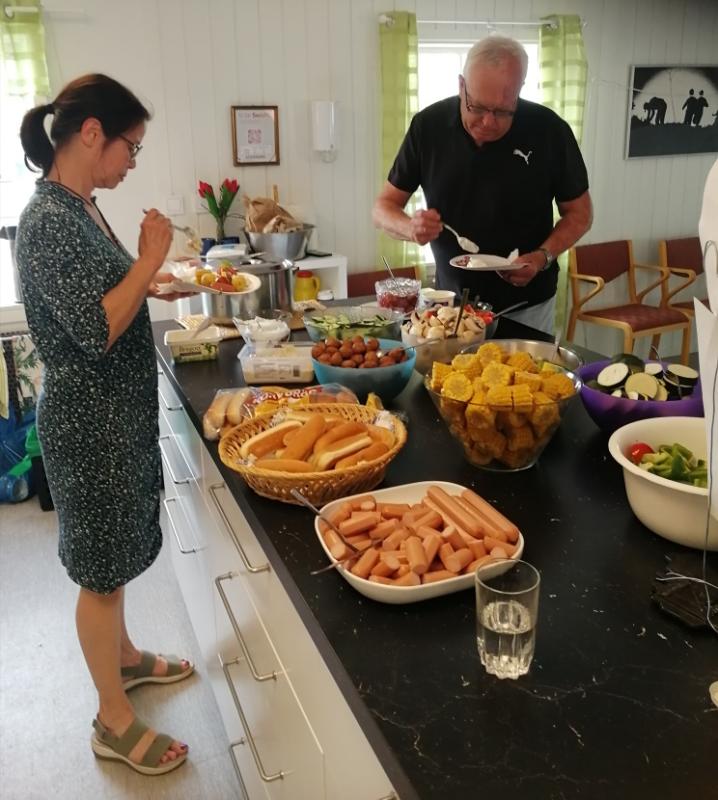 En man och kvinna som står framför en disk med mat.