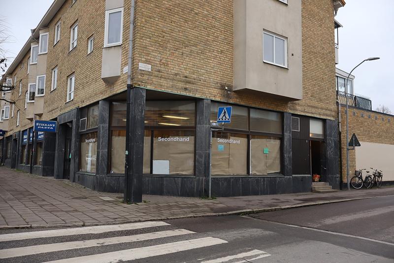 En hörnbyggnad med stora fönster täckta av brunt papper och 