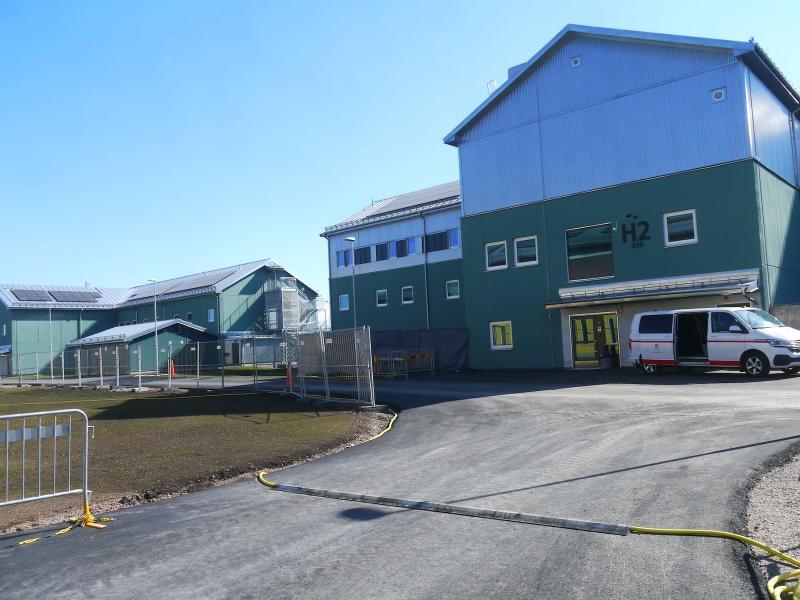 Gröna industribyggnader med skylten 