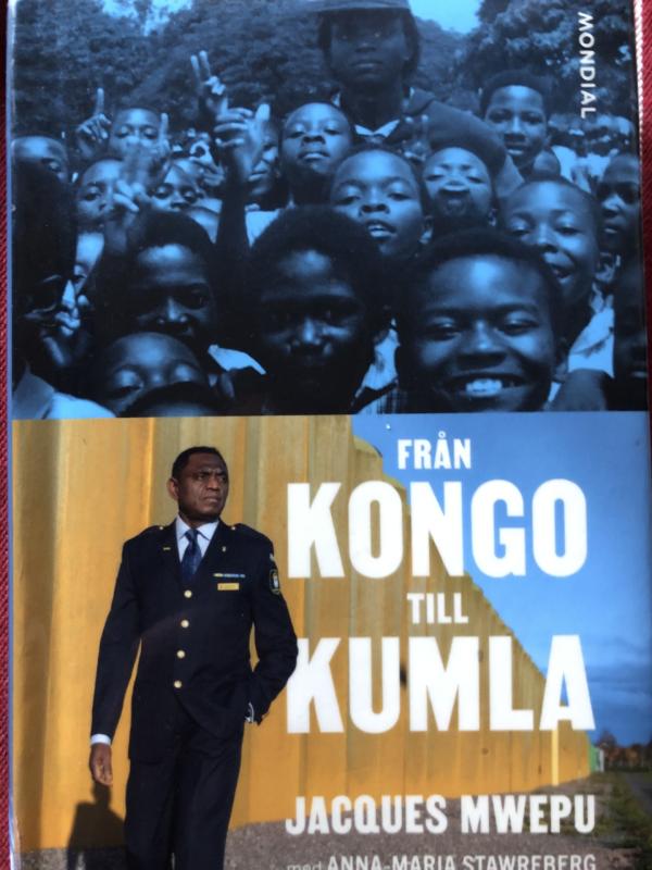 Bokomslag som visar en grupp leende barn i svart och vitt ovan, och en man i uniform som står framför en gul vägg under, med titeln 