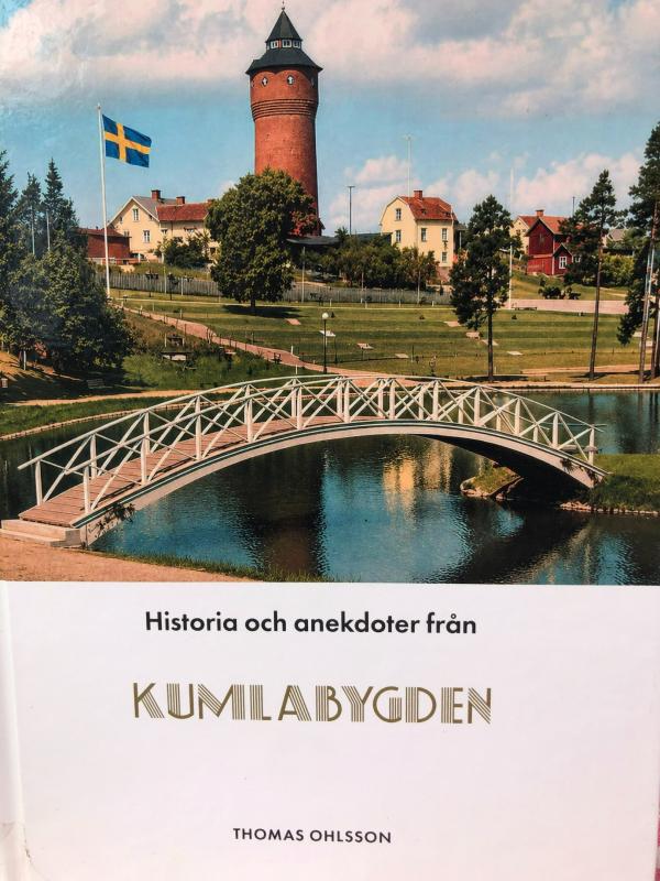 Bokomslag som visar en vacker vy över en svensk by med en bro, vatten, hus och ett torn; en svensk flagga syns. Titeln lyder ”Historia och anekdoter från Kumlabygden”.