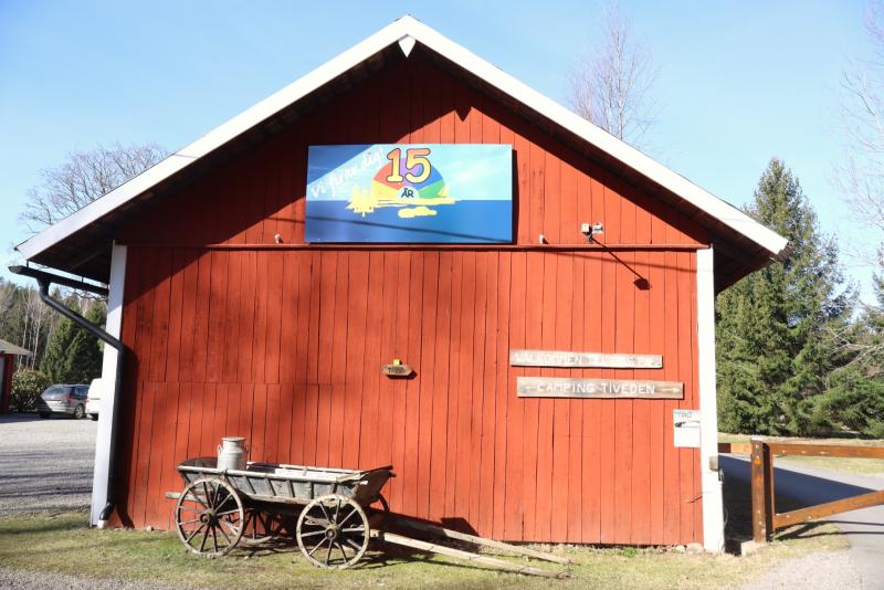 En röd träbyggnad med en blå skylt 