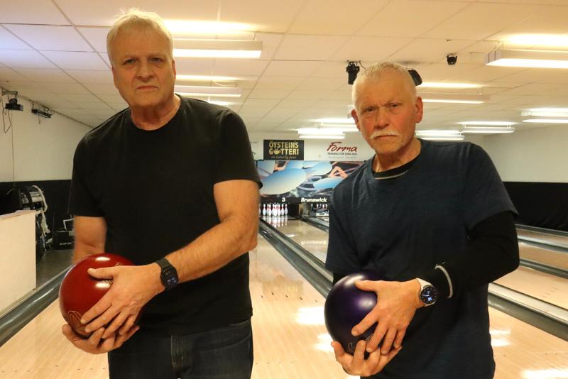 Två äldre män står i en bowlinghall med varsitt bowlingklot i händerna och iförda vardagskläder, med bowlingbanor bakom sig.