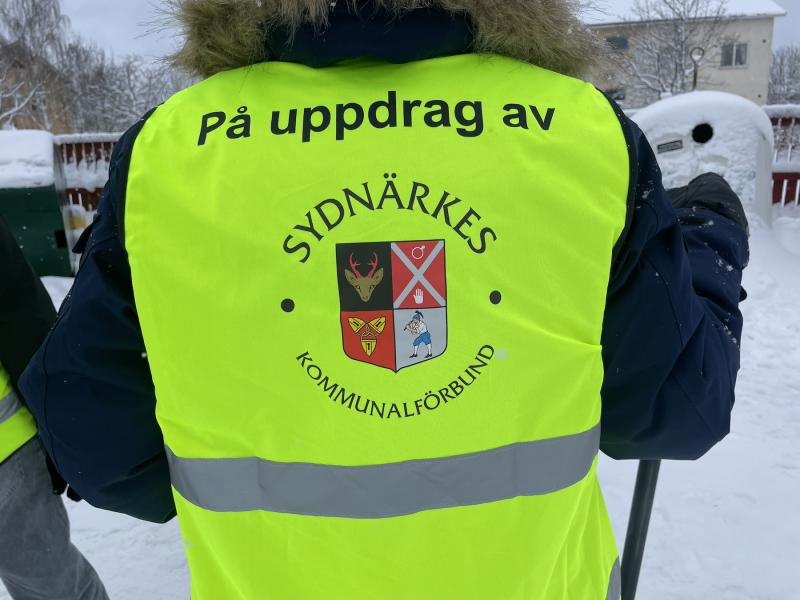 Baksidan av en person som bär en gul väst.