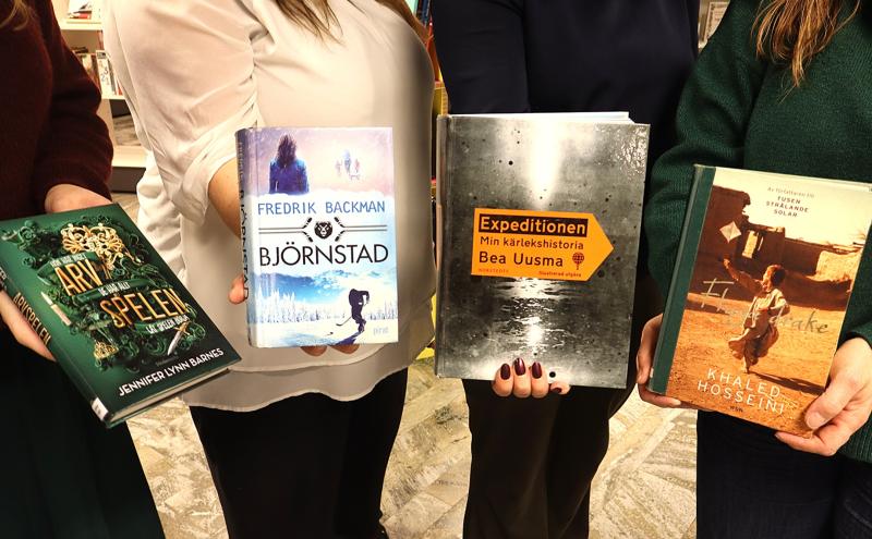 Fyra personer håller i varsin bok: 