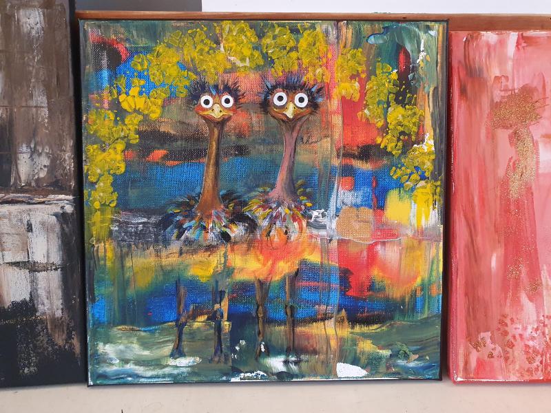 Färgstark målning av två tecknade strutsar med stora ögon som står tätt intill varandra, omgivna av abstrakta träd och ljusa, levande bakgrundsfärger.