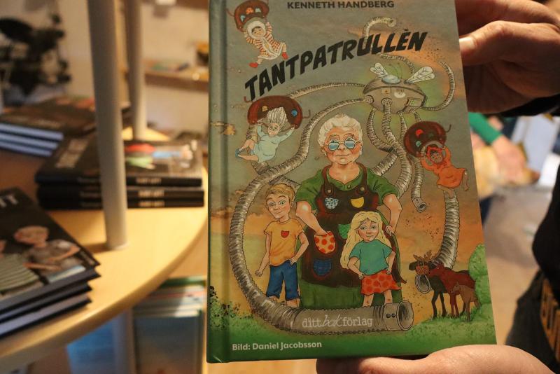 En person håller i en bok med titeln 